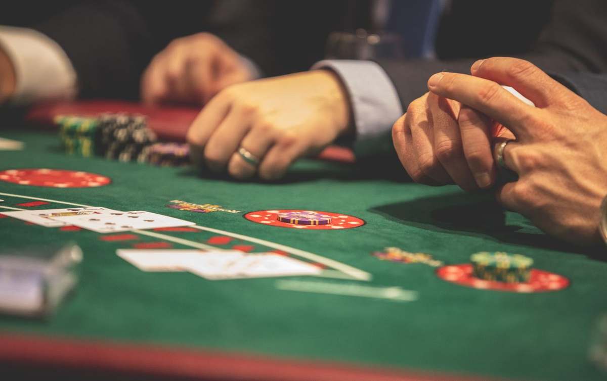 Tangan pemain memegang kartu di meja poker
